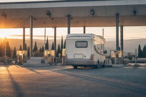 Italienische Autobahn mit Mautstation und Wohnmobil in der Abendsonne